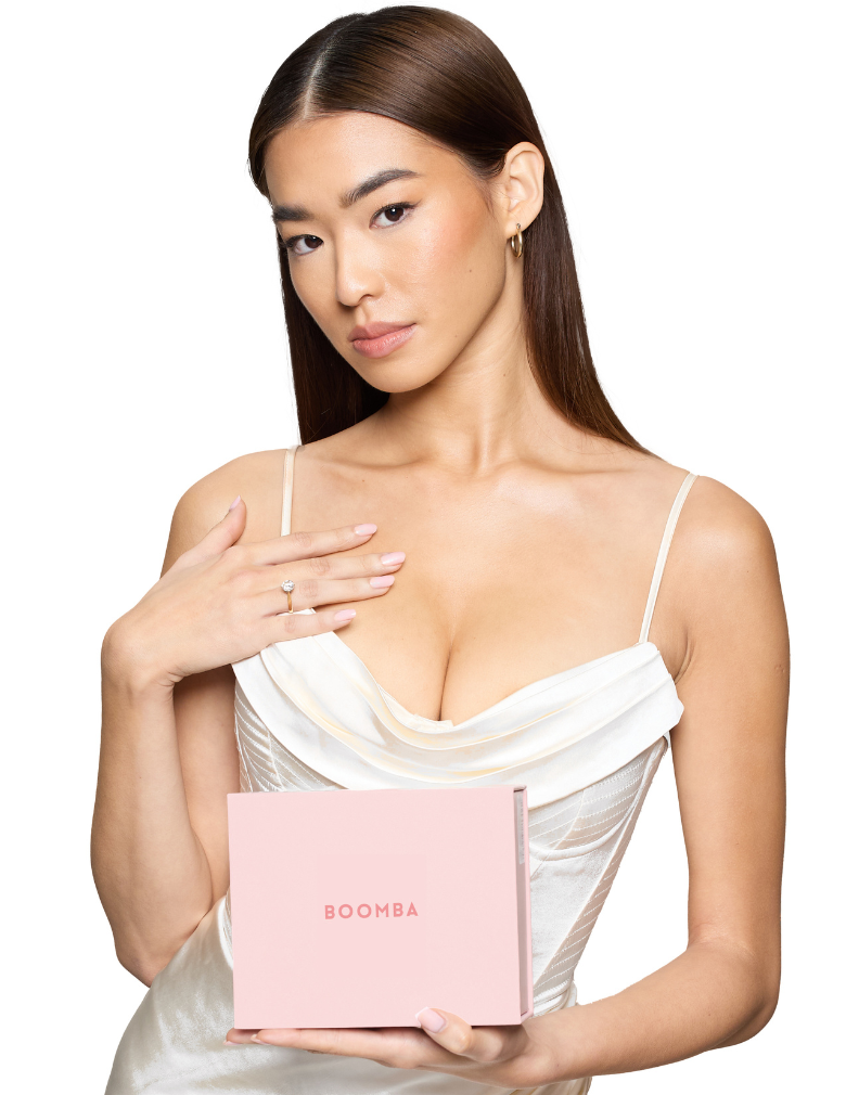 model with cleavage in a dress holding pink Boomba box