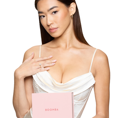 model with cleavage in a dress holding pink Boomba box